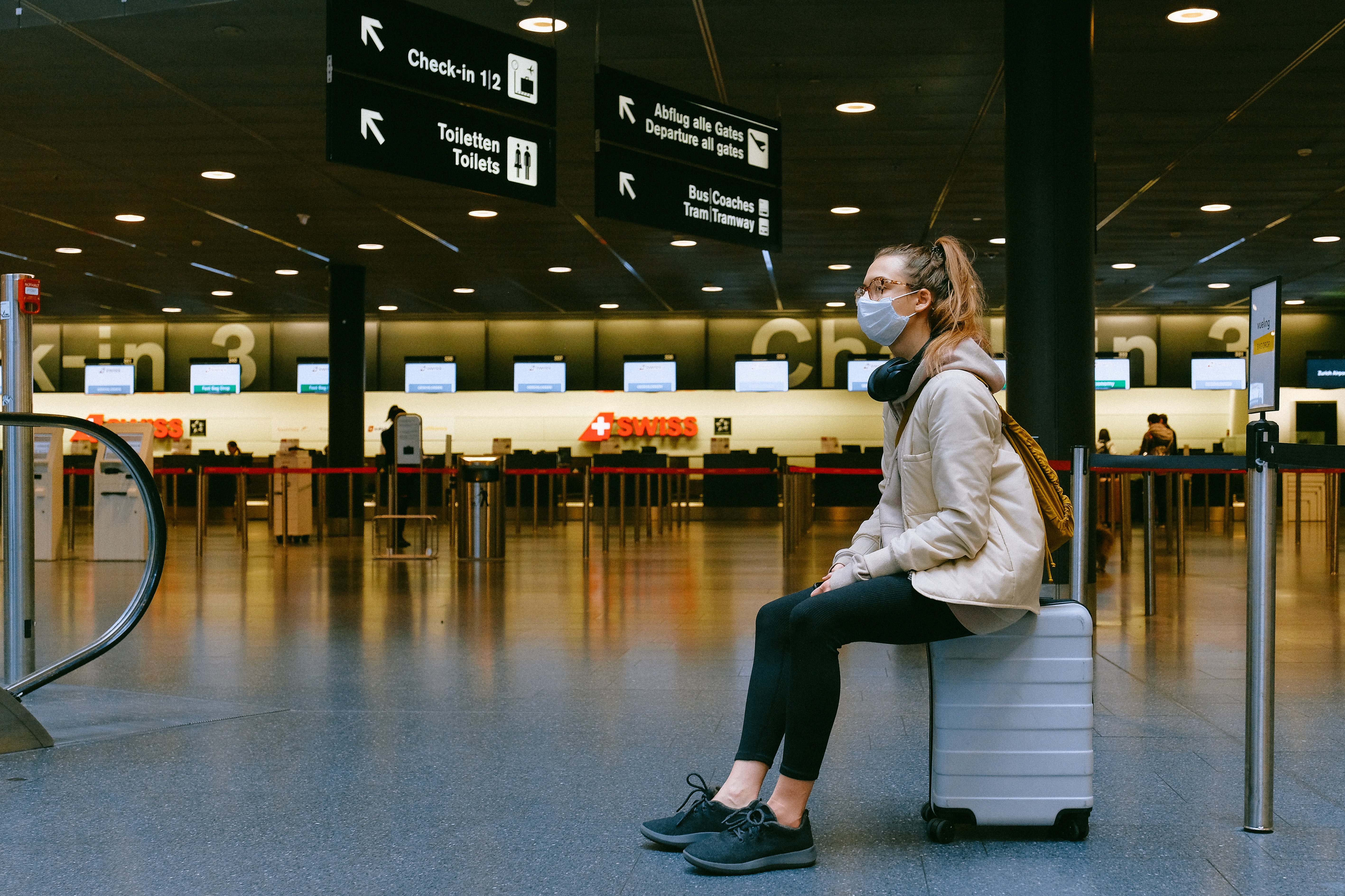 woman at airport waiting with mask on
